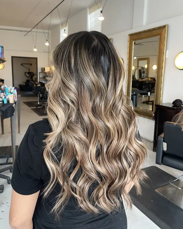Long dimensional blonde balayage with soft waves — hand-tied weft extensions by Aprille in San Diego